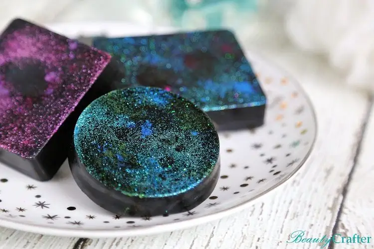 Space-inspired soap with dark blue and green colors on a plate