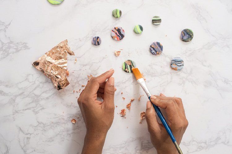 Making a galactic ref magnets using a paintbrush and golden leaves