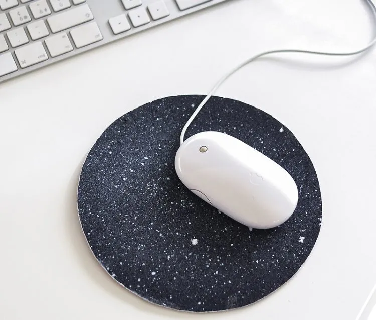 A white mouse on a Space inspired mouse pad