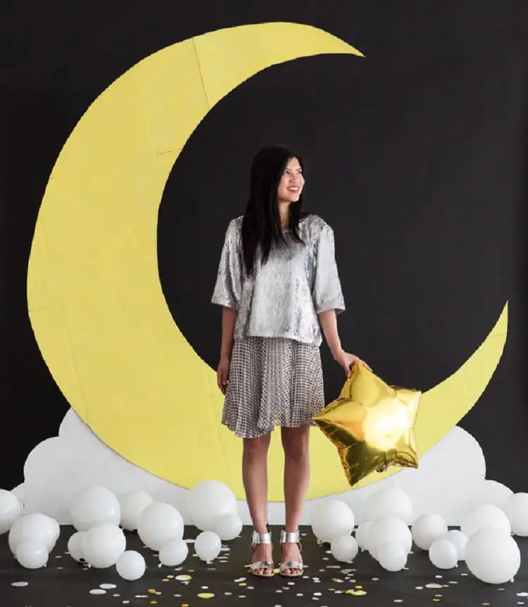 A Moon Photo Backdrop with a woman in a silver dress in front