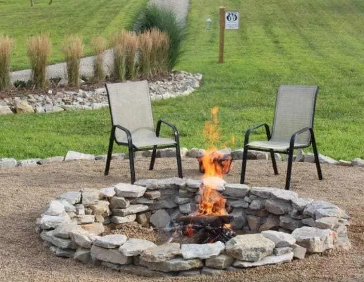 Stacked Stone Fire Pit in the middle of two chairs outdoors