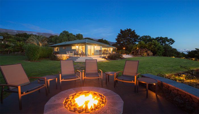 chairs surrounding a fire pit outside the house