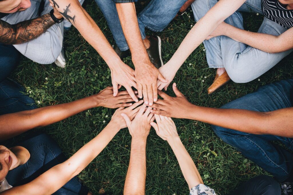 people showing teamwork by joining hands