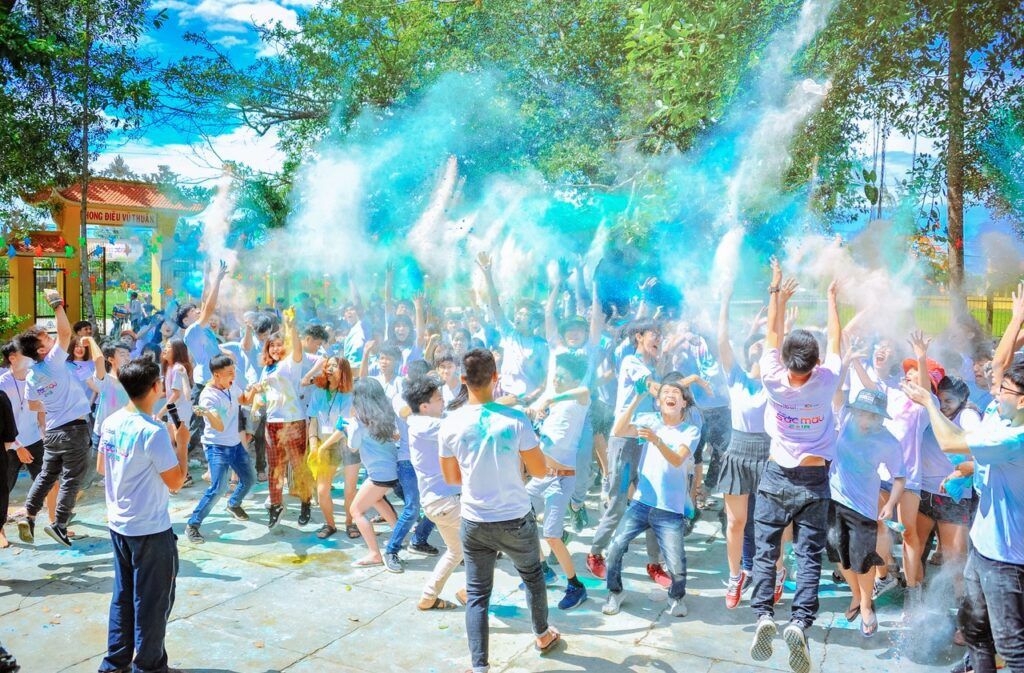 group of teens playing with color powder