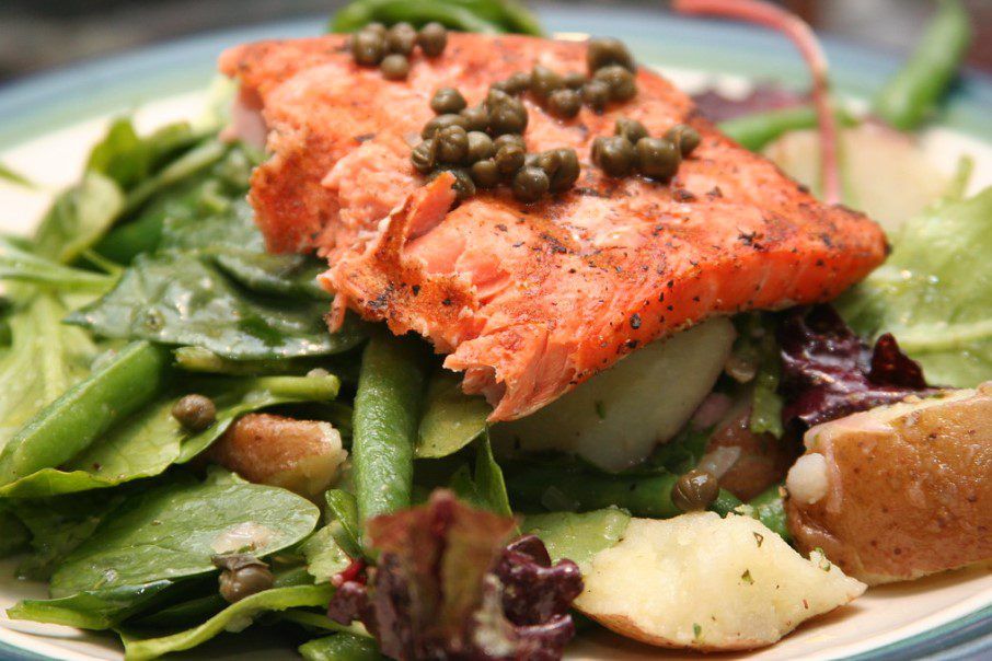 tuna steak capers, green beans, red potatoes, lettuce in a salad Nicoise