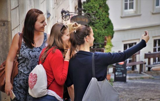 Three women taking a selfie, one with a bag that is on our list of easy sewing projects for beginners.