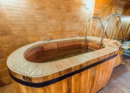 An indoor wooden mini pool with a metal handle